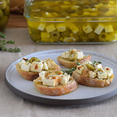 Queso feta marinado en aceite de oliva con aceitunas, naranja y tomillo: receta para un aperitivo de lujo y mucho más